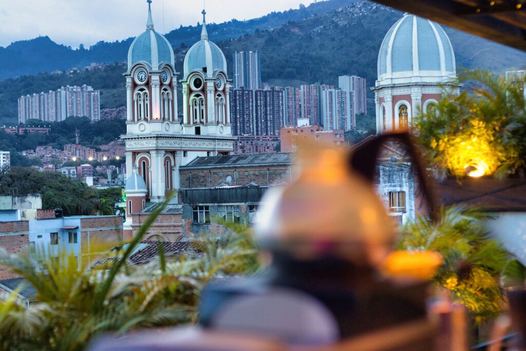 Cúpulas de la iglesia de Bello vistas desde la terraza del hotel, con una bebida en primer plano.