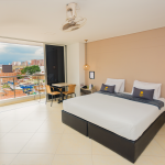 Habitación con el balcón abierto y vista a Bello desde el ventanal.