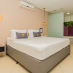 Habitación deluxe doble con cama king, lámparas colgantes y jardín vertical junto al baño.
