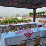 Terraza rooftop montada para un evento, con una mesa larga vestida y vista a la ciudad.