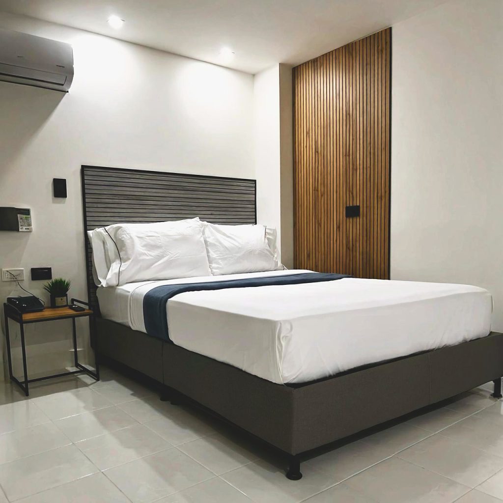 Dormitorio de la Suite Perlatto con cama doble, mesa de noche y aire acondicionado.